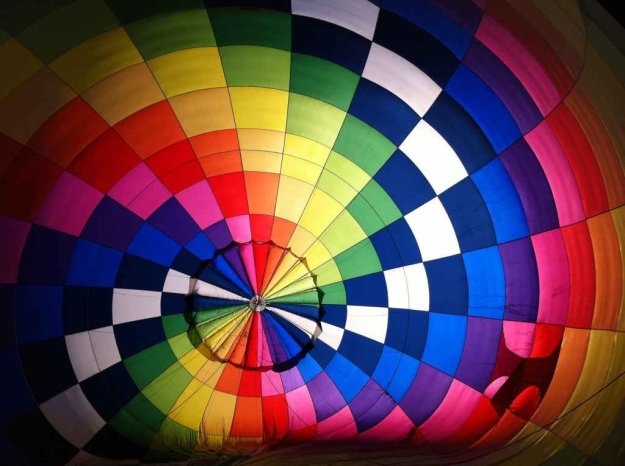 Binnenkant van een luchtballon met de print van felle, geblokte regenboogkleuren.