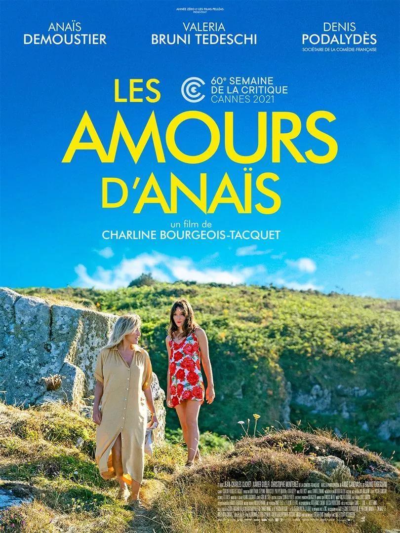 Hoofdrolspeelster Anaïs uit de speelfilm Les Amours d'Anaïs wandelt met schrijfster Emiily over groene heuvels langs de zee. Het is stralend zonnig weer. De lucht boven de kustlijn is helder blauw.