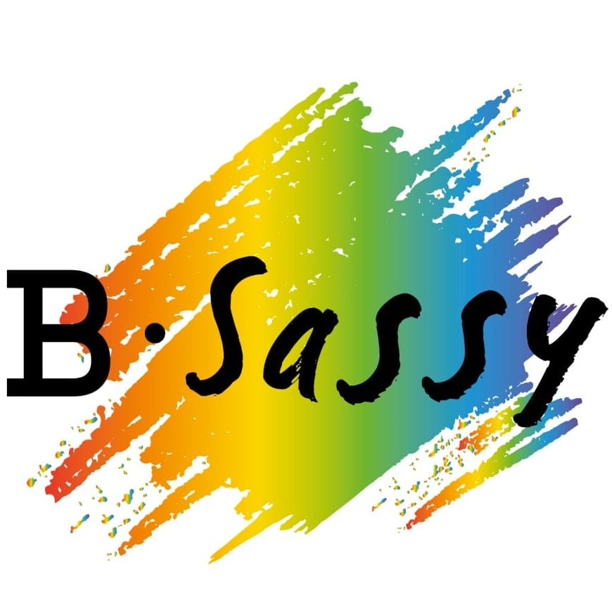 Zwarte letters B Sassy uitgeschreven in cursief gezette blokletters. Op de achtergrond staan vegen in de regenboogkleuren.